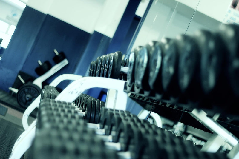 Gym dumbbells and fitness equipment — pre-workout and post-workout hydration timing