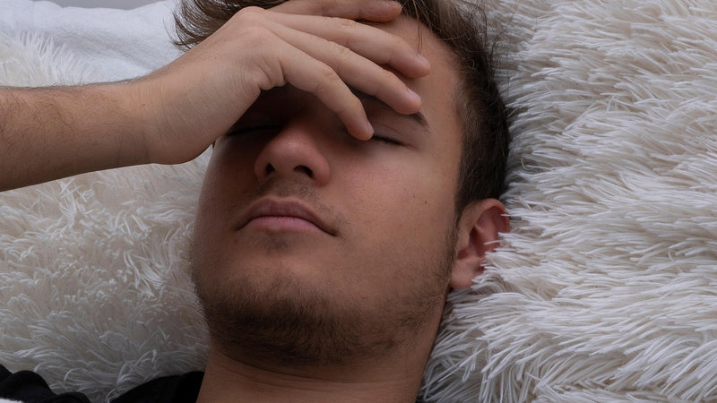Tired person experiencing fatigue and brain fog — common signs of dehydration
